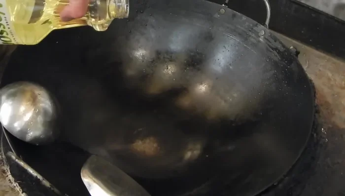 Heat oil in a wok or pan. Add ginger, garlic, and sliced white onion. Stir-fry briefly.