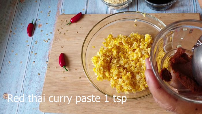 In a mixing bowl, combine the corn mush with red Thai curry paste, soy sauce, salt, and maize flour. Mix until a pliable dough forms. Adjust maize flour as needed for consistency.