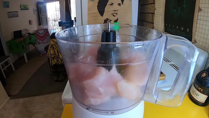 Chop chicken breasts into chunks. Add to food processor.