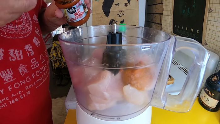 Add Thai red curry paste, fish sauce, sugar, rice flour, lime zest, and egg to the food processor. Blend until well combined.