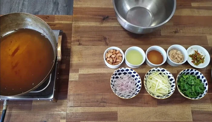 Prepare the sauce: In a bowl, combine chilies, palm sugar, fish sauce, and lime juice. Press and break down the palm sugar until dissolved.