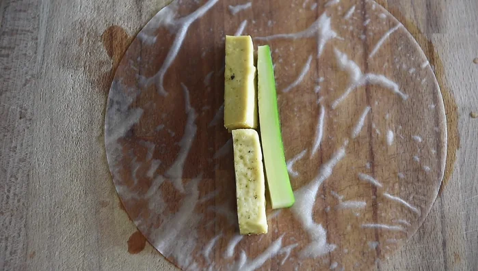 Assemble the spring rolls: Lay rice paper flat, add tofu, cucumber, vermicelli noodles, herbs (Thai basil, mint, cilantro), and lettuce. Roll tightly.