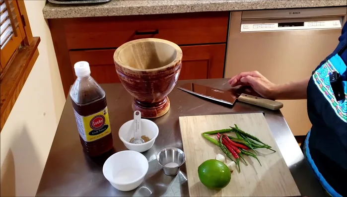 Prepare the dipping sauce: pound green and red chilies, garlic, and add lime juice, salt, sugar, mushroom seasoning, and fish sauce.