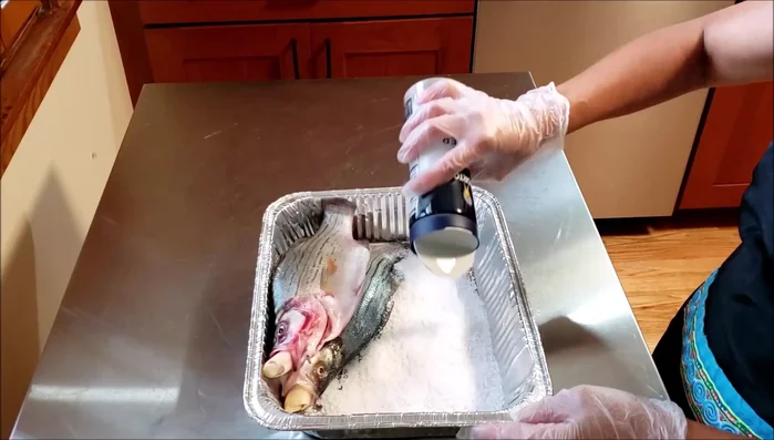 Pour kosher salt generously over the wet fish.