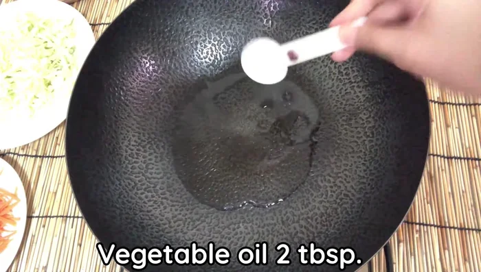 Heat vegetable oil in a pan. Add garlic, coriander root, and bell pepper; fry until fragrant.