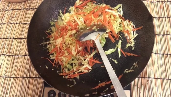 Add the cooked glass noodles to the vegetable mixture.
