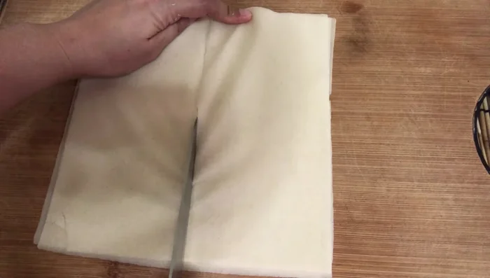 Place a spoonful of the filling onto the wrapper. Roll tightly, sealing the edges with the starch paste.