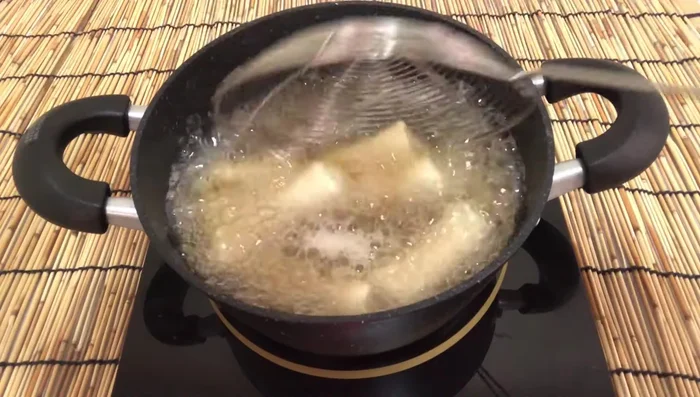 Fry the spring rolls until golden brown and crispy.