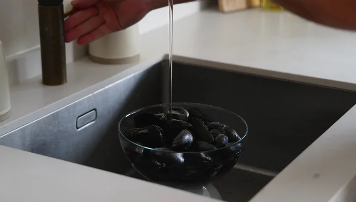 Rinse mussels under cold running water to remove sand and any unwanted parts. Discard any that float.