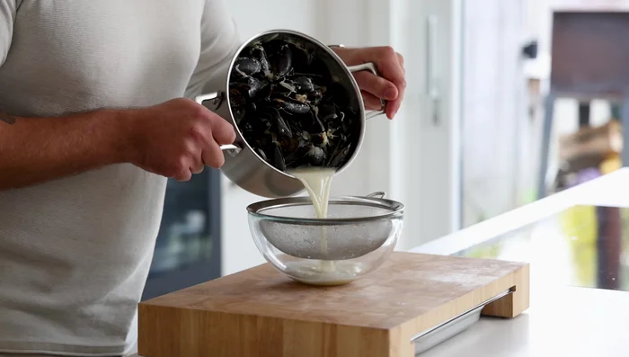 Remove lid, drain the liquid (save for later!), and cool mussels quickly. Remove mussels from shells.