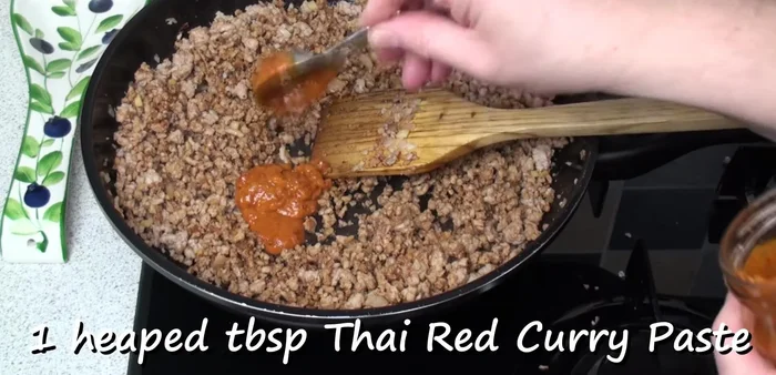 Add a heaping tablespoon of Thai red curry paste, a couple of tablespoons of Thai fish sauce, and a tablespoon of dark soy sauce. Mix well and stir fry for a couple of minutes.