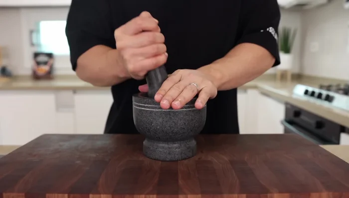Grind garlic, Thai chilies, and shallot into a rough paste using a mortar and pestle (or food processor). Avoid getting chili juice in your eyes!