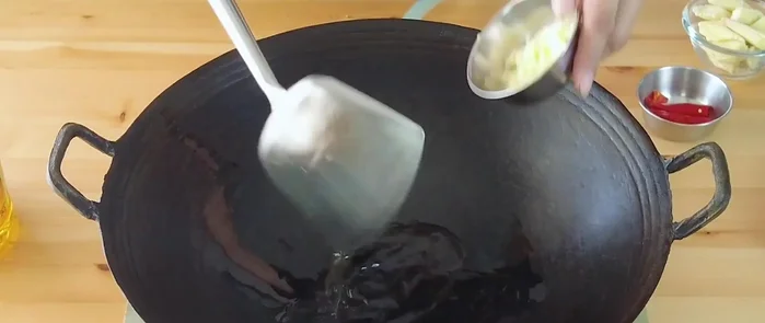 Heat oil in a wok, sauté garlic (and chilies if using).