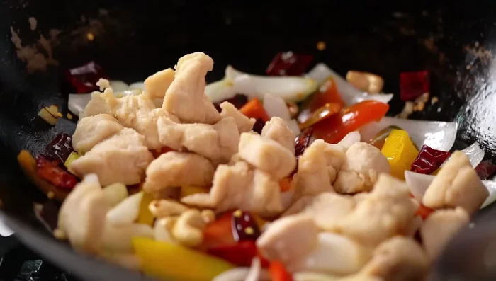 Add the cooked chicken and the sauce to the wok. Stir-fry until the sauce thickens and becomes glossy.