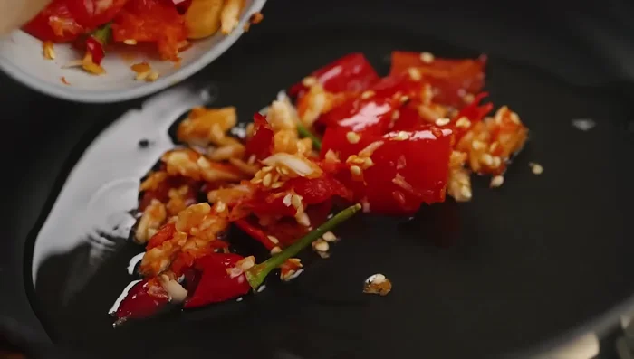 Heat oil in a pan. Add the chili and garlic paste and sauté until fragrant.