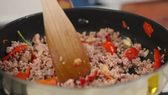 Add the meat to the pan and stir-fry until cooked.