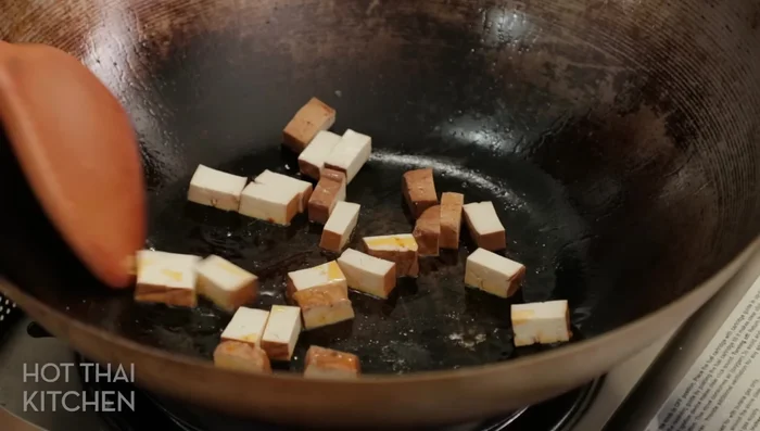 Pan-fry the tofu: Heat the pan and add the tofu, cooking until heated through. Avoid overcooking or making it crispy.