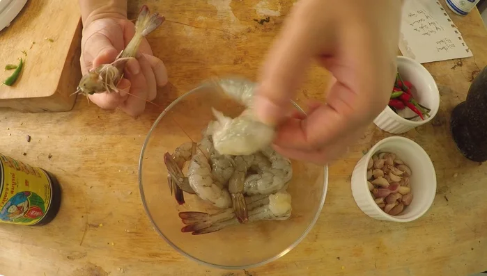 Clean and devein the shrimp. Remove shells, leaving tails on for aesthetics. Make a shallow cut along the back and remove the vein.
