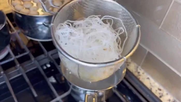 Cook noodles and bean sprouts: Cook rice noodles and bean sprouts in boiling water for a few seconds. Drain and place in bowls.