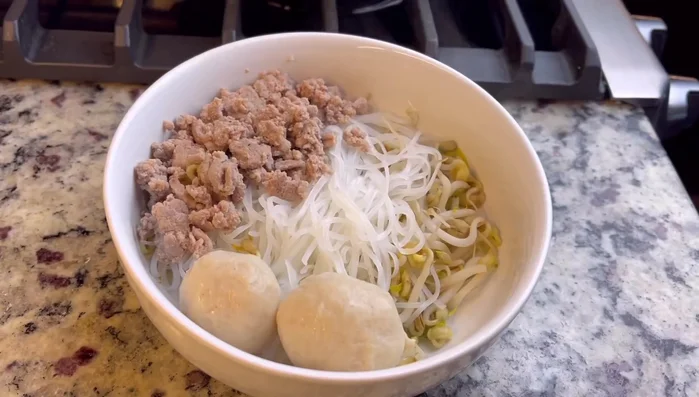 Assemble the soup: Add cooked ground meat or pork meatballs to the bowls. In a separate bowl, mix the broth with roasted peanuts, chili, fish sauce, lime juice, and sugar (adjust to taste).