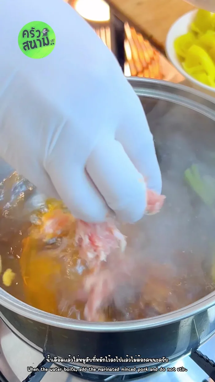 Add marinated pork: Once boiling, add the marinated minced pork. Do not stir; wait until cooked.
