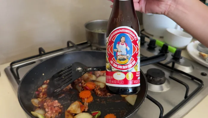 Stir in oyster sauce, fish sauce, and a little water.