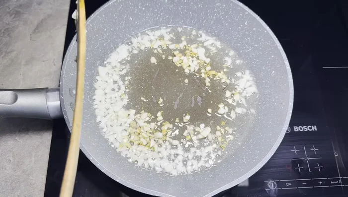Lightly brown garlic in a pan.