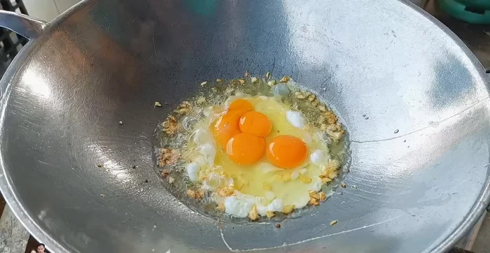 Crack 4 eggs into the pan and stir-fry until cooked.
