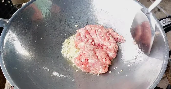 Add minced pork and stir-fry with garlic.