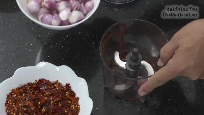 Blend roasted chilies, garlic, shallots, and coriander root using a blender or mortar and pestle.