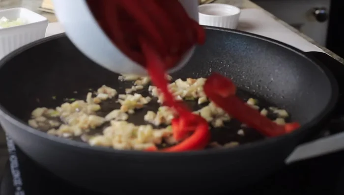 Add sliced red bell pepper and diced onion. Cook until softened and almost caramelized.