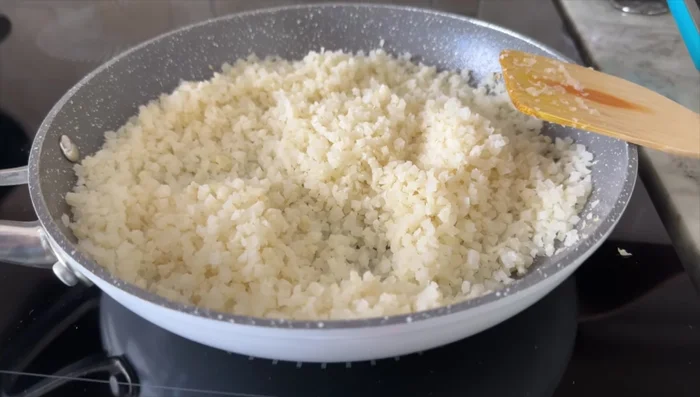 Cook frozen cauliflower rice in a dry frying pan over low to medium heat until slightly crispy. Season with salt and pepper.
