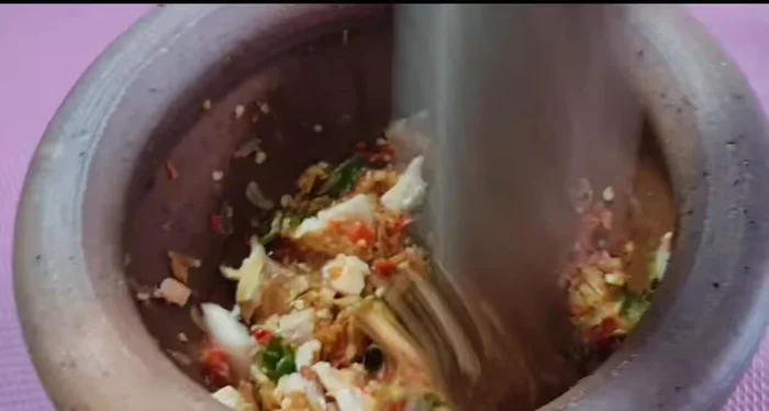 Add the cooked salmon and continue pounding.
