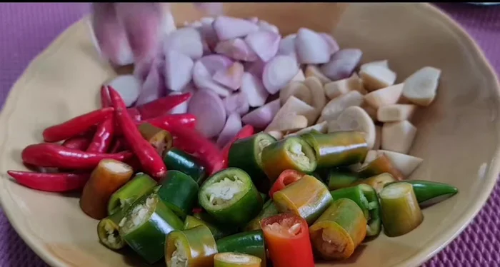 Chop chili peppers, shallots, garlic, green onions, and parsley.
