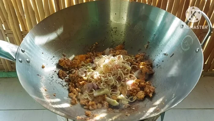 Add the sliced shallots, lemongrass, and chilies. Stir-fry everything together briefly. Do not overcook the aromatics.