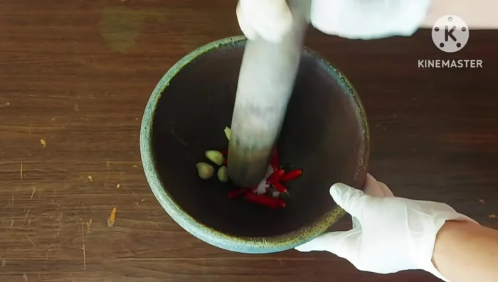 Prepare chili and garlic paste: Pound red chinda chilies, garlic, salt until smooth.