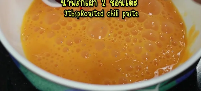 In a bowl, combine the beaten eggs with water, chili paste, seasoning powder, pepper, fish sauce, sugar, oyster sauce, and light soy sauce. Mix well.