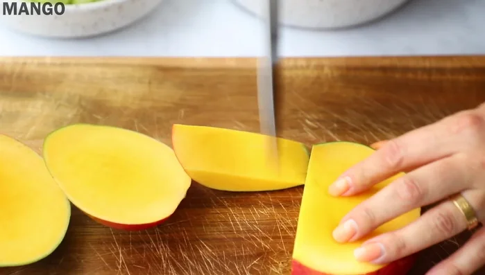 Cut mango flesh into thin slices, removing the skin.