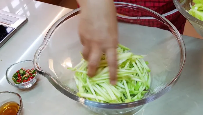 In a bowl, combine the shallots (slightly broken), chili (start with half), salt, sugar, fish sauce, ground dried prawns, and the sliced mango. Taste the mango and adjust the sugar and fish sauce accordingly. More sugar may be needed if the mango is sour.
