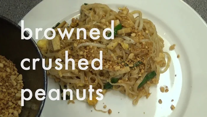 Squeeze lime juice over the noodles. Garnish with peanuts, fresh Chinese chives, and bean sprouts. Add a little sugar and chili powder to taste.