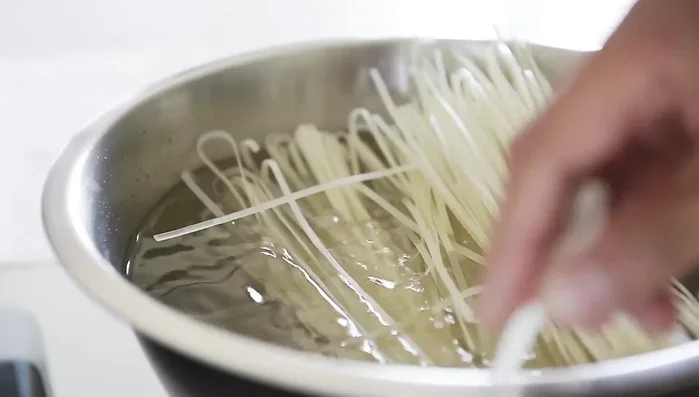 While tofu bakes, soak noodles in room-temperature water for 15 minutes (61.97). Prep broccoli and carrots into bite-sized pieces (63.78).