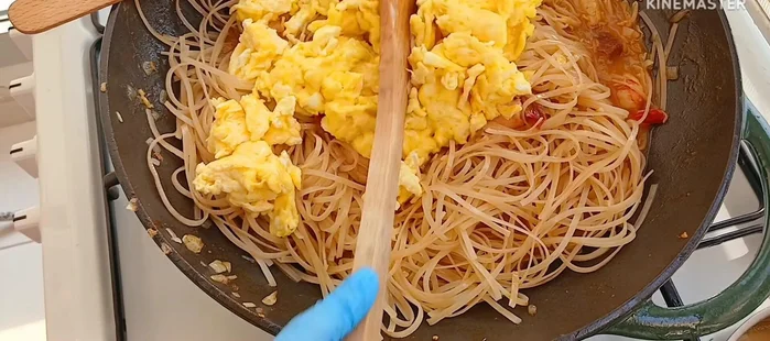 Add the scrambled eggs back into the noodles.
