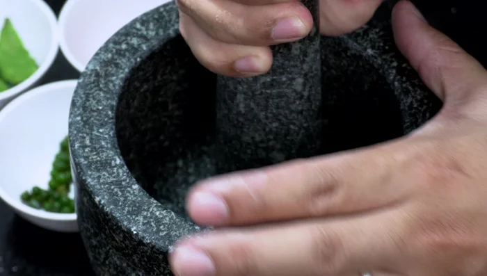 Prepare the stir-fry base: Pound the chilies, coriander root, and garlic in a mortar and pestle until finely crushed.