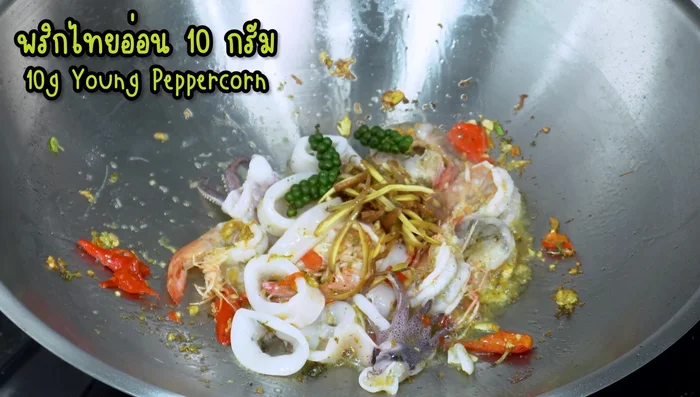 Add galangal, young peppercorns, and kaffir lime leaves. Stir-fry.