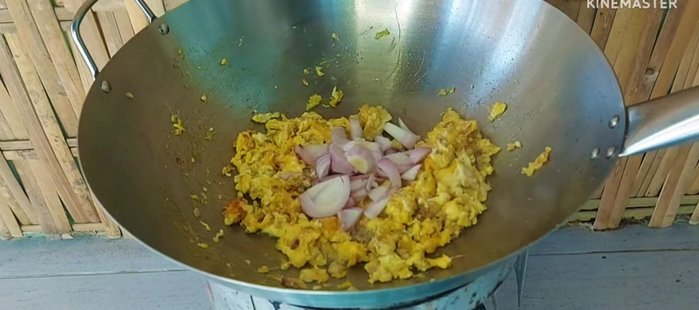 Add sliced shallots, green and red chilies, and stir-fry again.