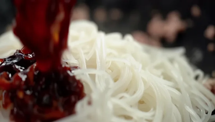 Add noodles and the sauce to the wok, stir-frying until the noodles absorb the sauce and the liquid evaporates.