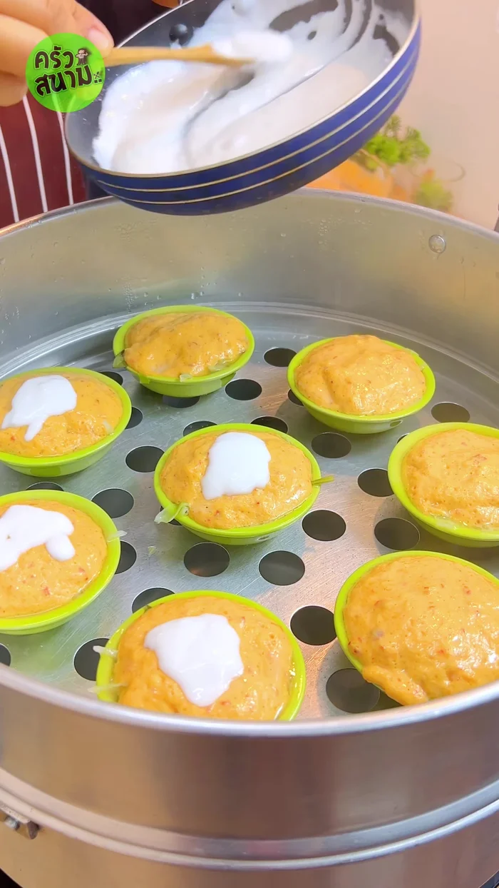 Finish: Turn off heat. Pour the prepared coconut milk topping over the steamed curry. Garnish with sliced kaffir lime leaves and red chili.