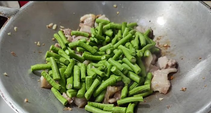 Add the yardlong beans and water from rinsing the mortar (or plain water).