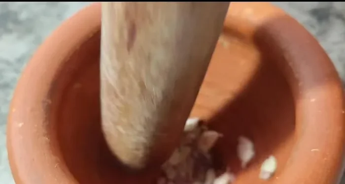 Pound 10 cloves of garlic (no need to peel).