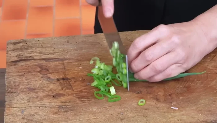 Mince the green part of the chard. Chop three cloves of garlic and 10g coriander stems. Cut coriander roots into pieces.